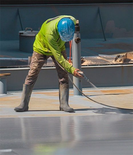 Worker spraying coating on the floor